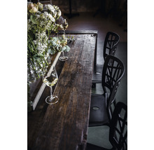 Esstisch aus Holz mit Blumenschmuck und Gläsern sowie Stühlen