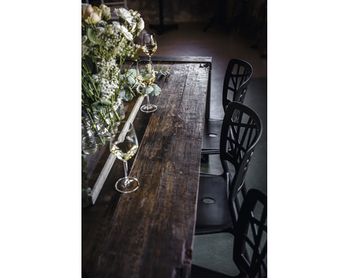 Esstisch aus Holz mit Blumenschmuck und Gläsern sowie Stühlen