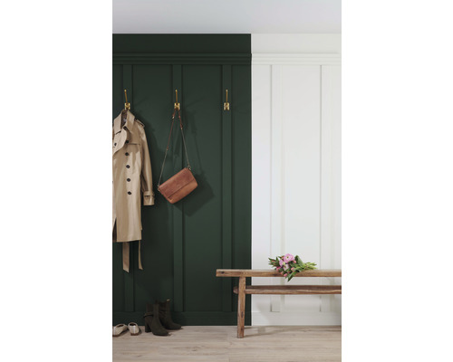 Eingangsbereich mit dunkelgrüner Wandvertäfelung, Garderobenhaken, Mantel, Handtasche, Bank, Blumen und Schuhen.