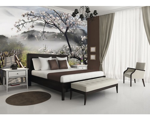 Schlafzimmer mit Fototapete Berglandschaft mit Kirschblüten, Bett, Nachttisch, Sitzbank, Sessel, Teppich und Vorhängen