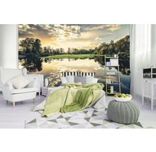 Schlafzimmer mit Fototapete eines Sees bei Sonnenuntergang, Sessel, Bett, Teppich und Beistelltisch