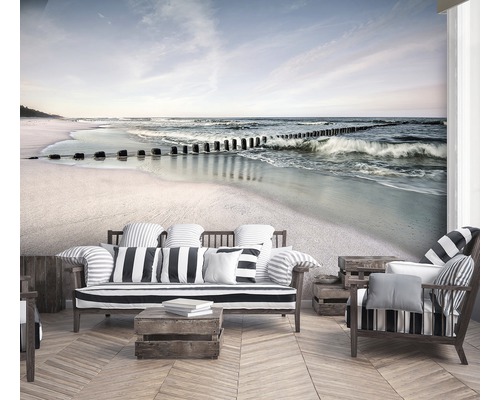 Wohnraum mit Fototapete, die einen Strand mit Wellen und Holzpfosten zeigt