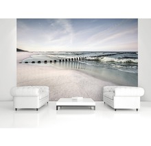 Wohnraum mit Fototapete, die einen Strand mit Wellenbrechern zeigt