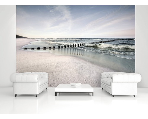 Wohnraum mit Fototapete, die einen Strand mit Wellenbrechern zeigt