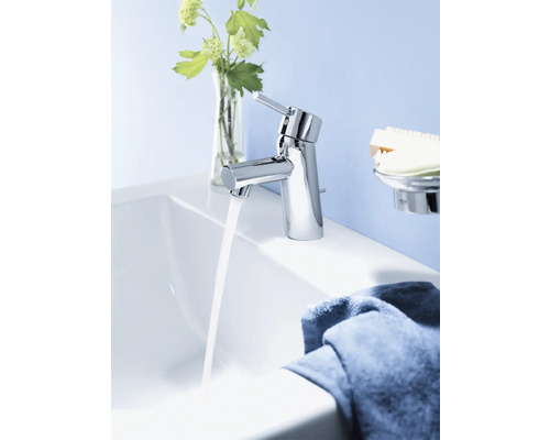 Verchromter Waschtischmischer mit laufendem Wasser in einem Badezimmer