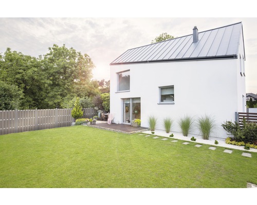 Ansicht eines modernen Hauses mit Garten, Rasen und Holzzaun