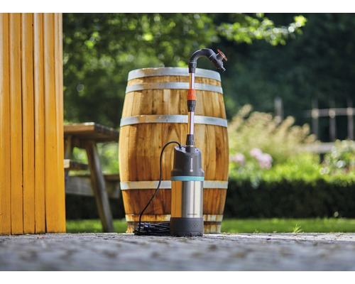 Gardena Regenfasspumpe vor einem Holzfass im Garten