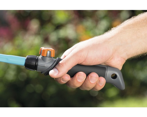 Hand hält ein Gartenschlauch-Anschlussstück mit Regler