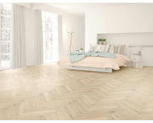Heller Raum mit Fischgrätenparkett, Bett und Fenstern