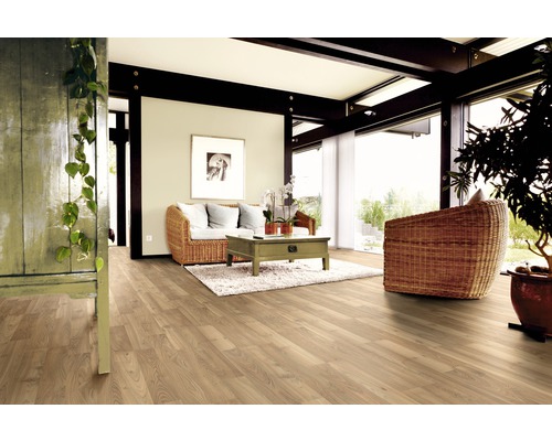 Heller Wohnraum mit Holzboden, Rattansessel und Holztisch auf Teppich