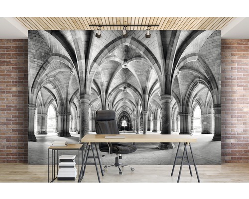 Fototapete mit einem Gang aus Steinbögen in Schwarzweiß hinter einem Schreibtisch