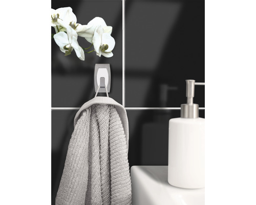 Badezimmer-Szene mit Handtuch an einem Haken, Seifenspender und einer Orchidee