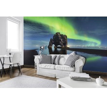 Wohnzimmer mit Fototapete einer Felsformation unter grünem Polarlicht am Himmel