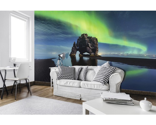Wohnzimmer mit Fototapete einer Felsformation unter grünem Polarlicht am Himmel