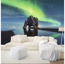 Wohnzimmer mit Fototapete eines Felsens im Meer unter Nordlichtern
