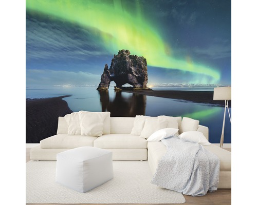 Wohnzimmer mit Fototapete eines Felsens im Meer unter Nordlichtern