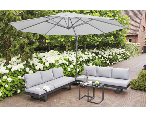 Gartenszene mit zwei Sofas, einem Tisch und einem Sonnenschirm für den Außenbereich.