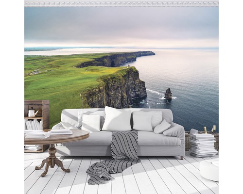 Wohnraum mit Fototapete irische Küstenlandschaft, Sofa, Tisch und Dekoration