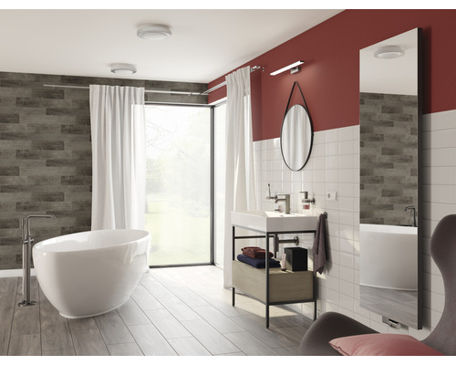 Helles Badezimmer mit Badewanne, Waschtisch und Spiegel
