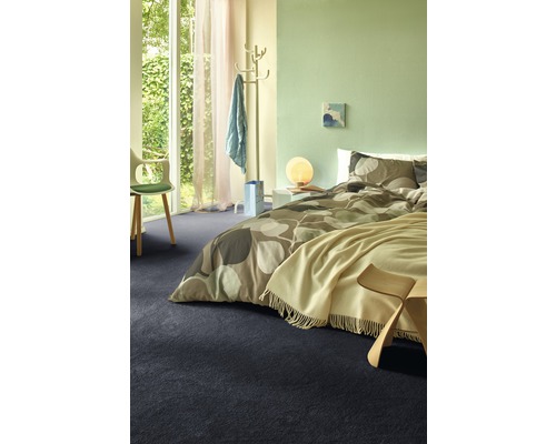 Schlafzimmer mit Bett, Teppich und heller Einrichtung