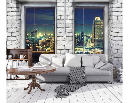 Wohnzimmer mit Sofa, Tisch und Blick auf die Stadt bei Nacht