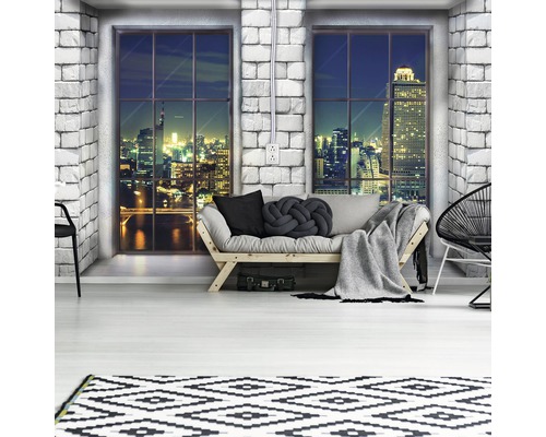 Modernes Wohnzimmer mit Sofa, Teppich und Blick auf die Skyline bei Nacht