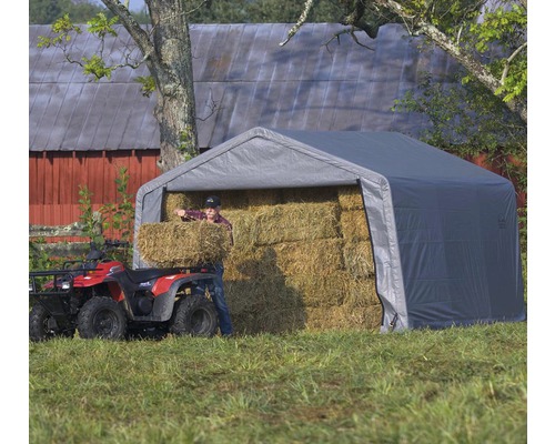 Graues Lagerzelt mit Heuballen und Person
