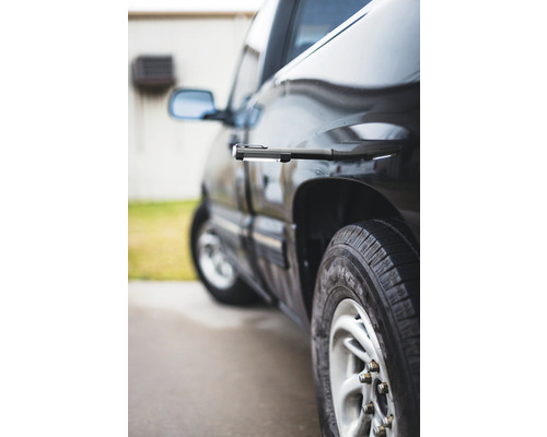 Schwarzes Auto mit angebrachter Arbeitsleuchte zur Inspektion