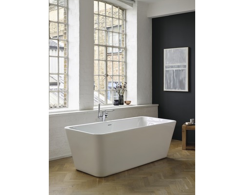 Freistehende Badewanne in einem hellen Badezimmer mit großen Fenstern und Holzboden