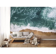 Wohnzimmer mit Fototapete, die eine Küstenlandschaft mit Meer und Sandstrand zeigt.