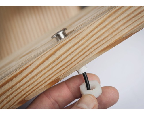 Detailansicht eines Holzelements mit einer Schraube und einer Kabelverschraubung.