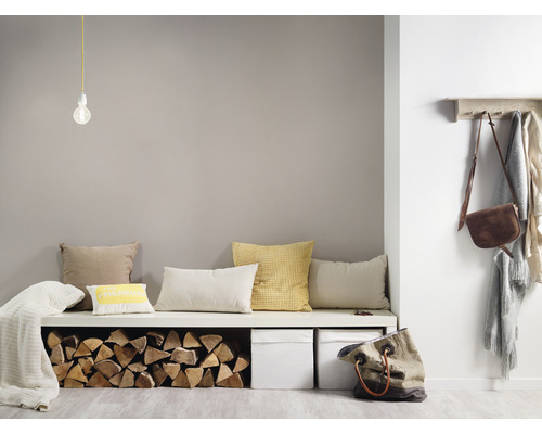 Heller Raum mit Sitzbank, Kissen, Holzscheiten, Aufbewahrungsboxen, Lampe, Kleiderhaken und Taschen für eine freundliche Atmosphäre