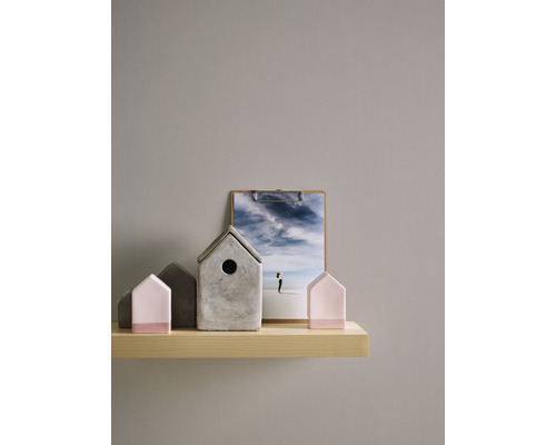 Dekorative Hausmodelle aus Beton und Holz auf einem Regal mit einem Bild