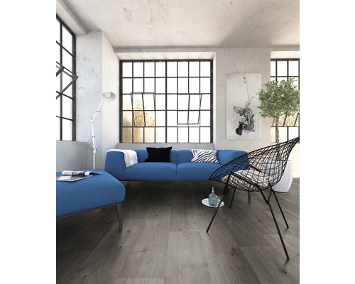 Heller Raum mit Sofa, Sessel und großem Fenster mit Sprossen