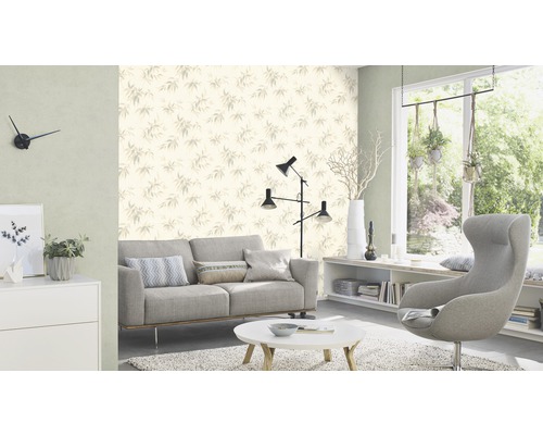 Wohnzimmer mit Sofa, Sessel, Tisch und Tapete mit Blattmuster für eine helle und organisierte Atmosphäre.