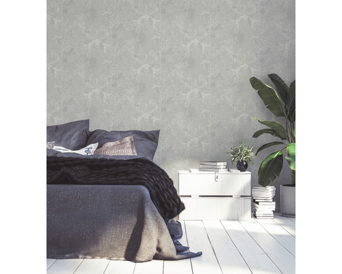 Schlafzimmer mit gemusterter Tapete, Bett, Nachttisch und Zimmerpflanzen