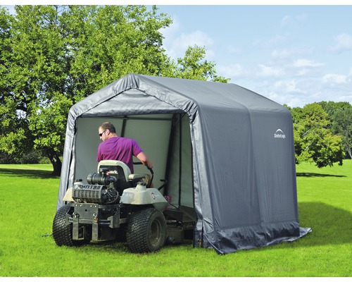 Gartenszene mit einer Rasenmähertraktor-Garage und einem Rasenmäher