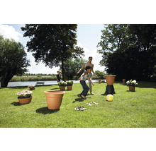 Szene im Garten mit spielenden Kindern und Pflanzgefäßen.