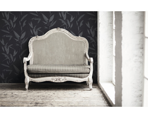 Antikes Sofa vor floral gemusterter Tapete