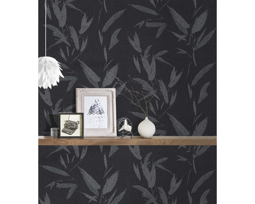 Zimmer mit dunkler Tapete mit Blattmuster und einem Regal mit Dekorationsgegenständen