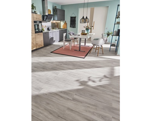 Helle Küche mit Esstisch, Stühlen und Laminatboden.