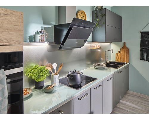 Helle Küche mit Dunstabzugshaube, Spüle und Kochfeld.