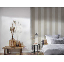 Schlafzimmer mit gestreifter Tapete, Nachttischlampe, Dekoration und Bett