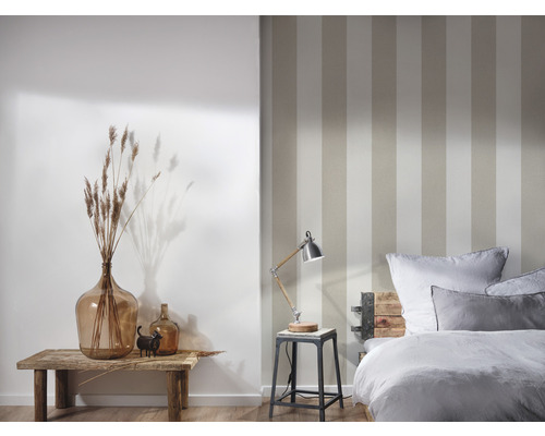 Schlafzimmer mit gestreifter Tapete, Nachttischlampe, Dekoration und Bett