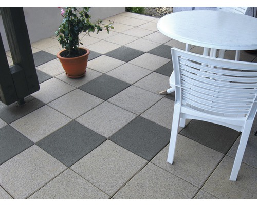 Terrasse mit quadratischen Betonpflastersteinen, Gartenmöbeln und Pflanze