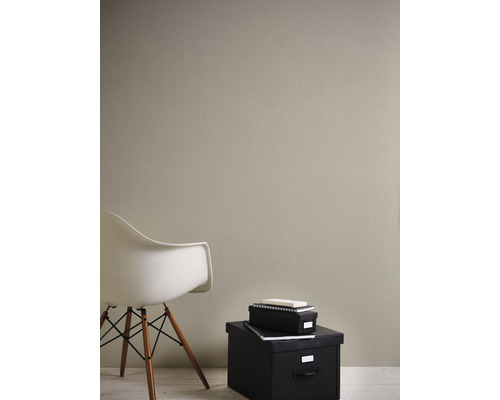 Raumansicht mit strukturierten Tapeten, einem Stuhl und schwarzen Aufbewahrungsboxen