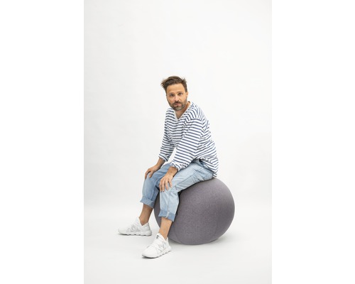 Mann sitzt auf einem Gymnastikball