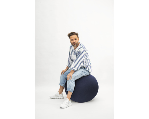 Mann sitzt auf einem Gymnastikball.