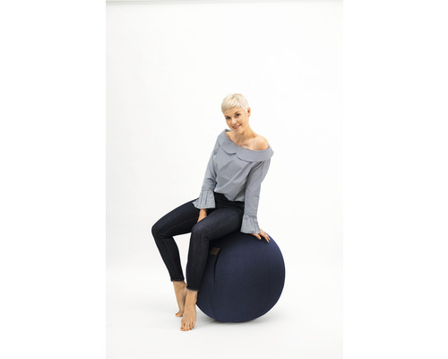 Frau sitzt auf einem Gymnastikball.