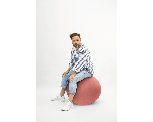 Mann sitzt auf einem Gymnastikball